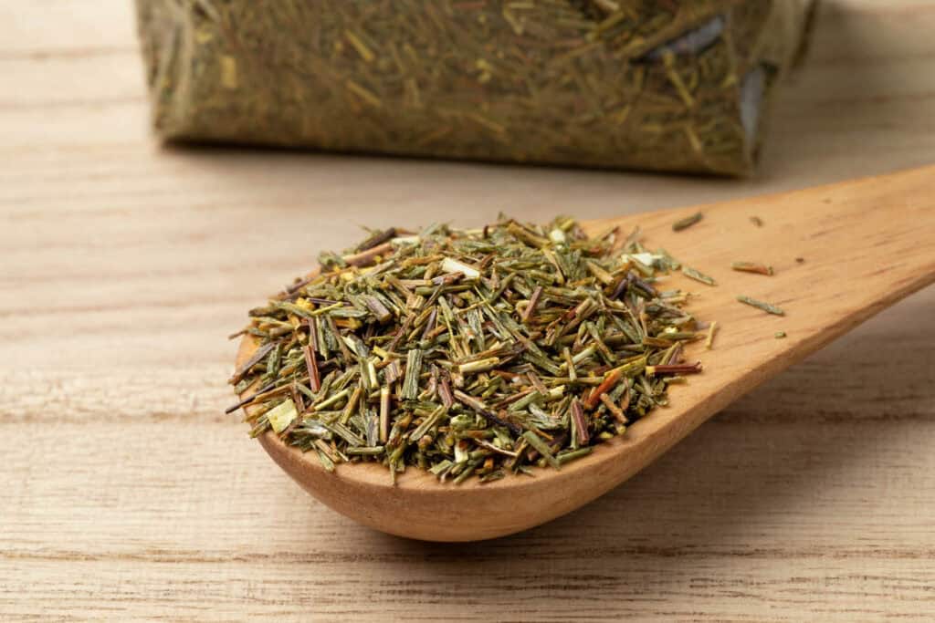 Green rooibos in a wooden spoon